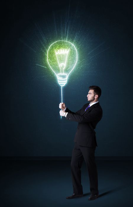 Businessman hold a shining idea bulb on a blue background