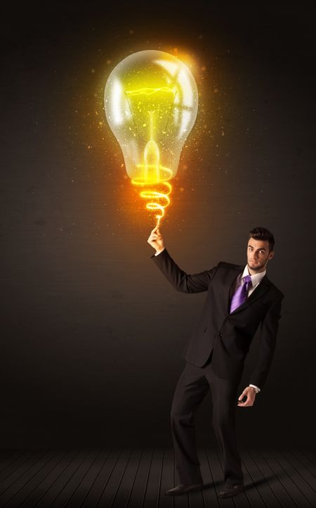 Businessman holding a shining idea bulb