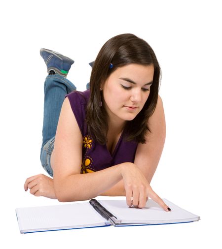 female student with a notebook on the floor over a white background