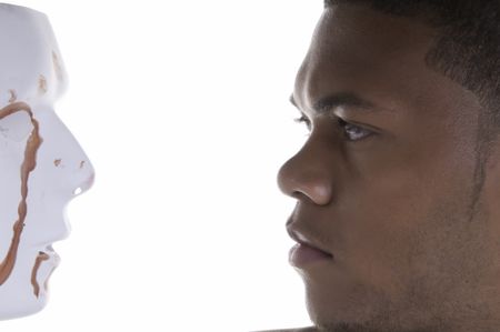 Face-off - young black man contemplates blood-stained mask
