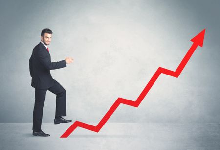 Business person climbing on red graph arrow