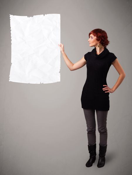 Beautiful young girl holding crumpled white paper copy space