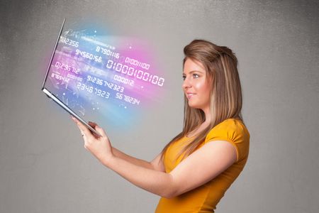 Attractive casual woman holding laptop with exploding data and numers