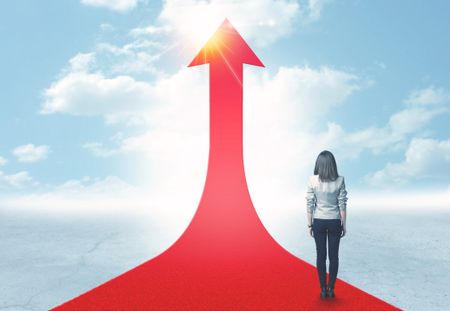 Concept of the road to success with a businesswoman standing on a red arrow