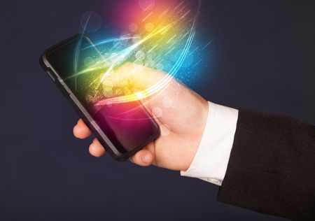 Hand holding smart phone with abstract glowing lines concept