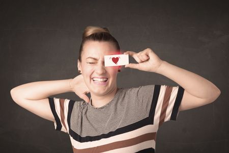 pretty-girl-holding-paper-red-heart-272602583 Pretty girl holding paper with red heart drawing concept