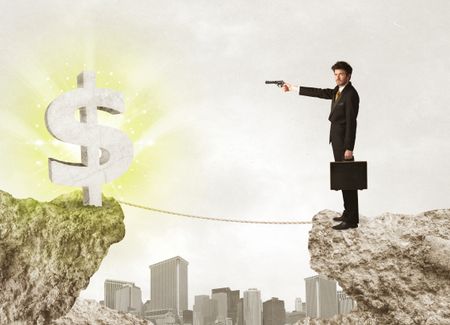 Businessman standing on the edge of mountain with a shining dollar mark on the other side