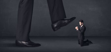 Giant person stepping on a little businessman concept on background