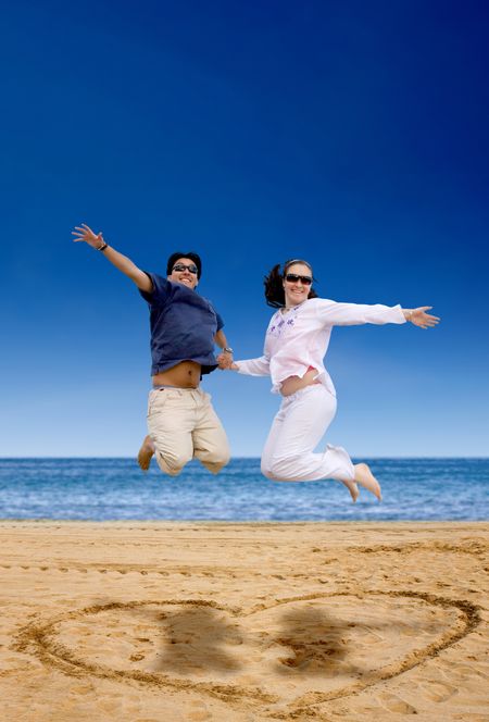 beach couple jump with plain blue sky