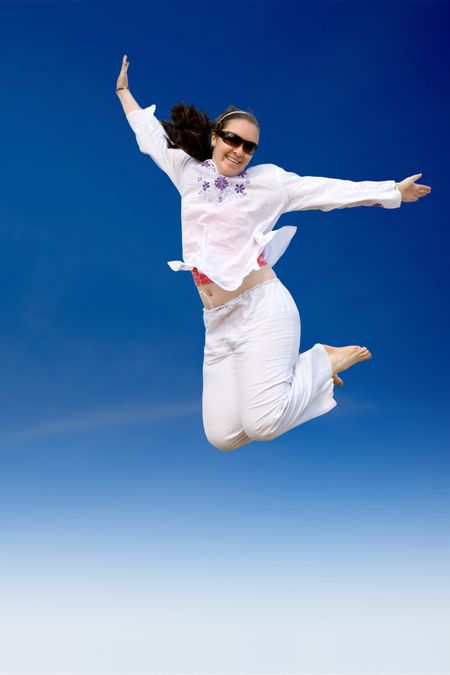 girl jumping of joy over a blue sky