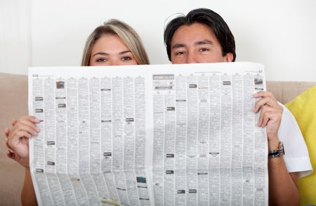 Couple covering their faces with a newspaper