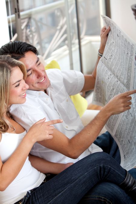 Couple at home reading the newspaper