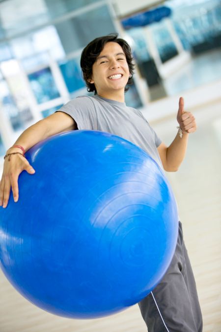 Thumbs up gym man with a pilates ball