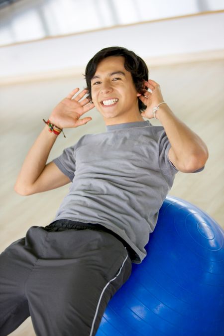 Man at the gym doing sit-ups smiling
