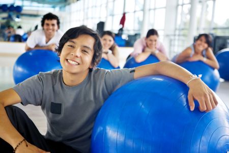 man portrait at the gym smiling with  a pilates ball