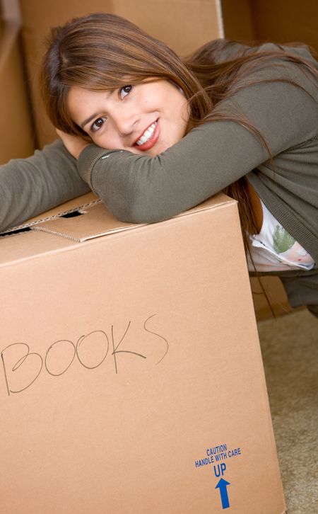 Removal girl leaning on a box filled with books