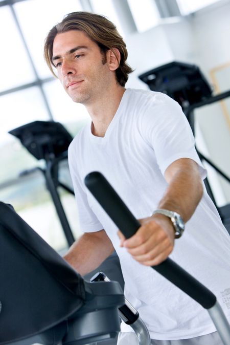 man at the gym doing exercise on a cardio machine