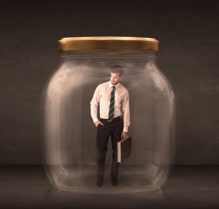 Businessman shut into a glass jar concept on background