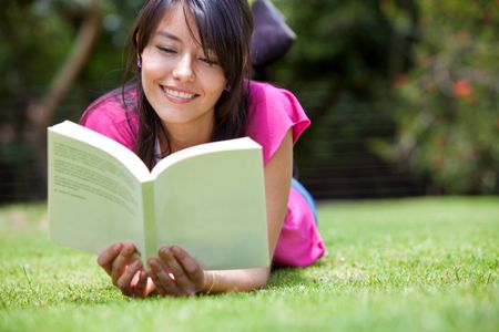 Beautiful woman reading a book outdoors