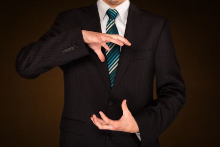 Businessman holding something in front of his body

