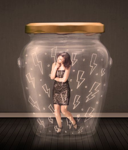 Businesswoman inside a glass jar with lightning drawings concept on background