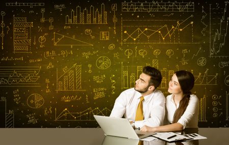 Business couple sitting at black table with hand drawn diagram background