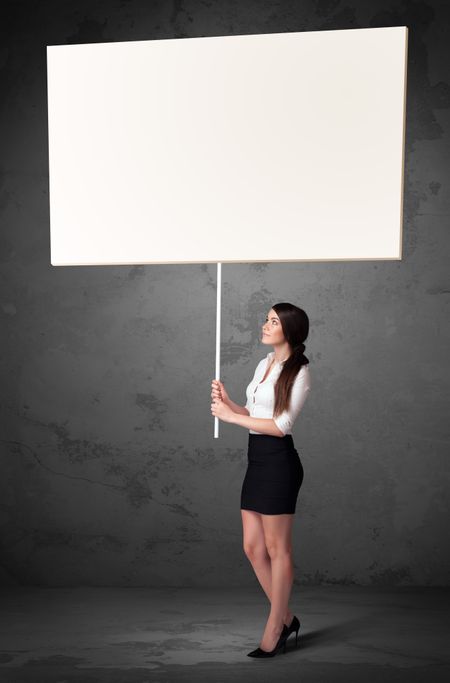 Young businesswoman holding a blank whiteboard
