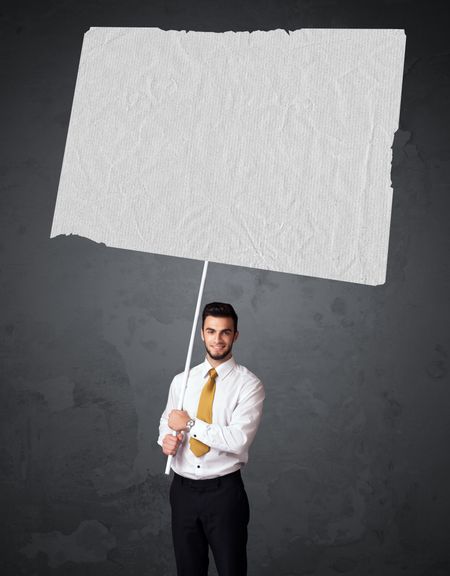 Young businessman holding a big blank booklet paper