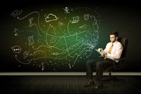 Businessman sitting in chair holding tablet with media icons concept on background