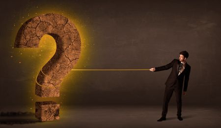 Business man pulling a big solid question mark stone concept on background