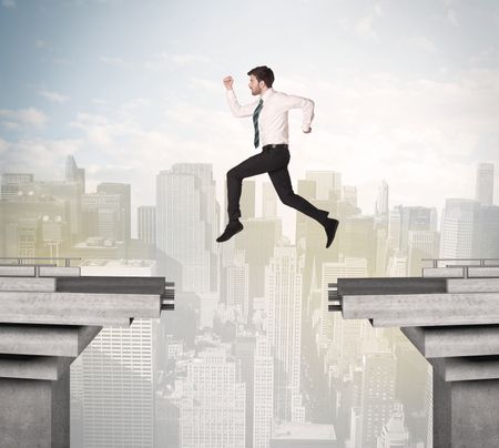 Energetic business man jumping over a bridge with gap concept