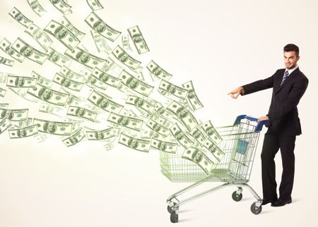 Businessman pushing a shopping cart and dollar bills coming out of it