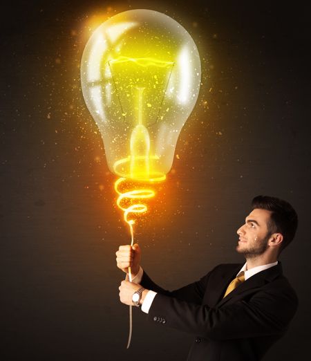 Businessman holding a shining idea bulb