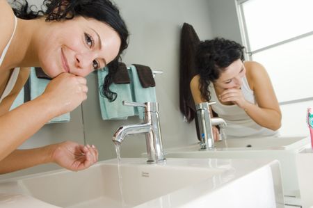 Girl washing her face in sink