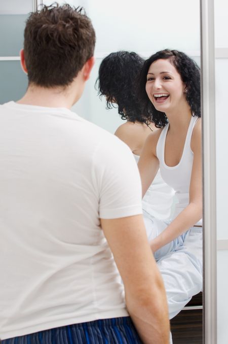 Woman laughing at guy in bathroom.