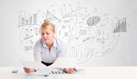 Business woman at desk with hand drawn charts at the background