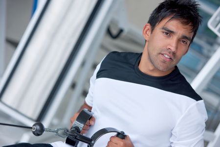 man at the gym doing exercise on a machine with weight