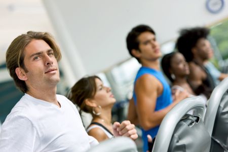 group of people at the gym on cardio machines