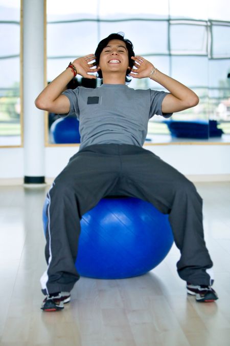 man at the gym doing sit-ups on a pilates ball