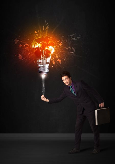 Businessman with an explosion bulb on black background