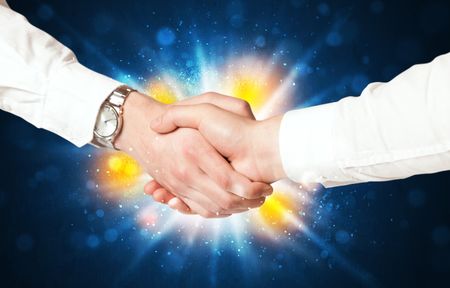 Two business men shaking hands with a successes agreement with explosion 