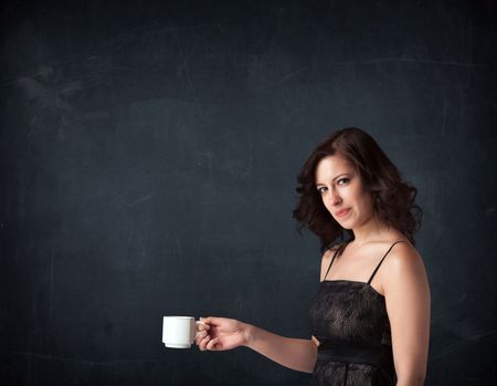 Businesswoman standing and holding a white cup on a black background