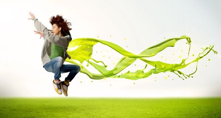 Pretty girl jumping with green abstract liquid dress concept in nature