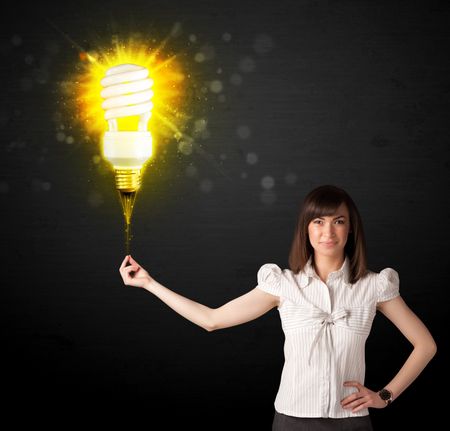 Businesswoman hold a shining eco-friendly idea bulb on a black background