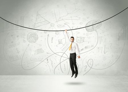 Businessman hanging on a rope with analysis and graphs background