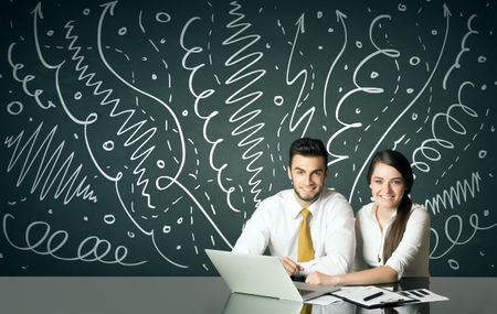 Business couple sitting at table with drawn curly lines and arrows on the background

