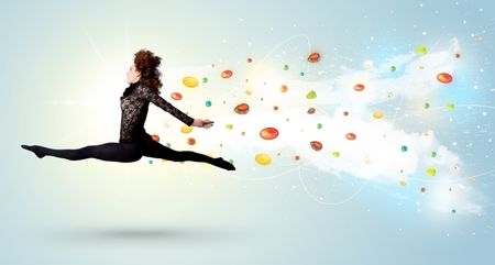 Beautiful woman jumping with colorful gems and crystals on the background concept