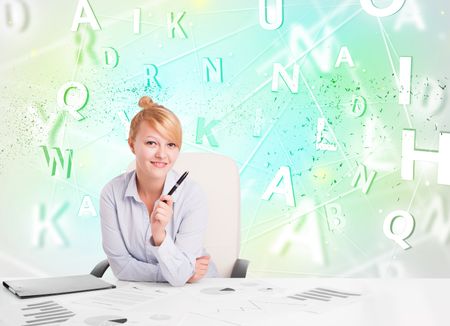 Business woman at white desk with green word cloud