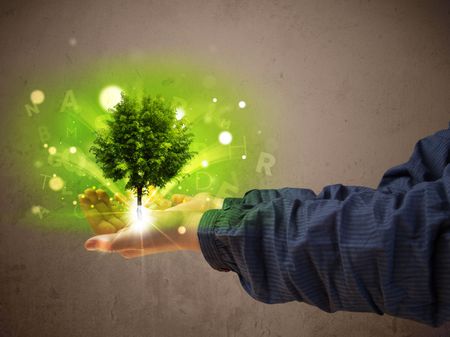 Young woman holding a glowing tree in her hand