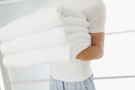 Close up of a guy holding clean towels.